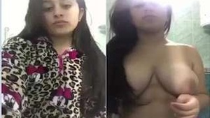 Watch a hot girl strip naked and flaunt her large breasts