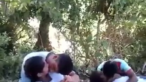 College students share a passionate kiss in public while surrounded by friends