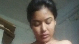 A stunning Indian babe plays with her big tits in a seductive solo video